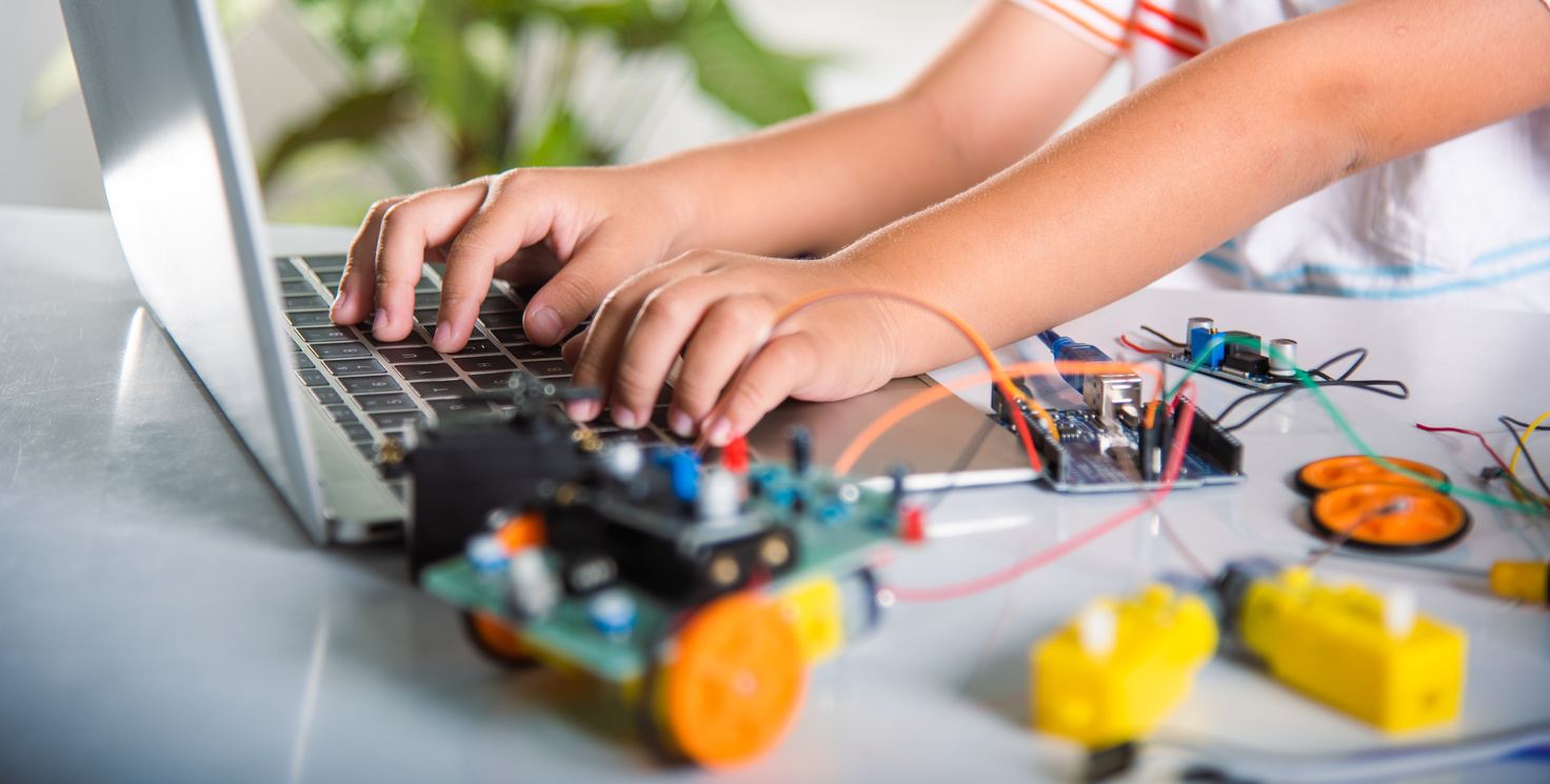 Asian kid boy learns coding and programming with laptop for