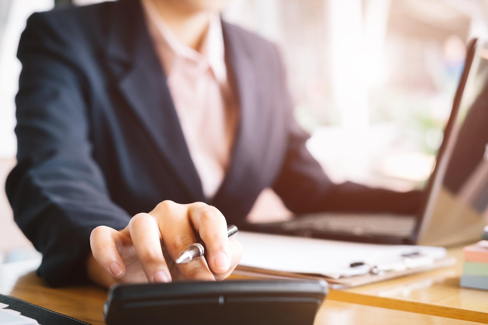 Business Woman Using a Calculator to Calculate